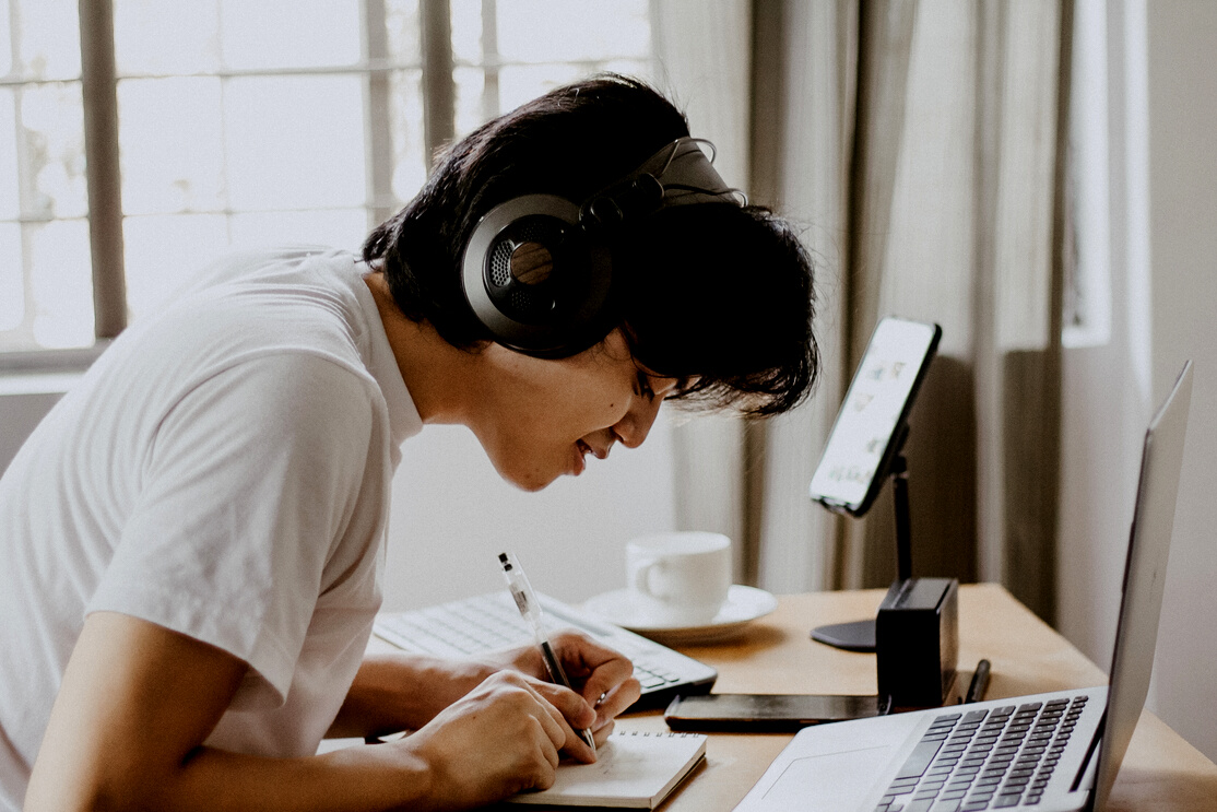 Student with Headphones Using Laptop for Online Class